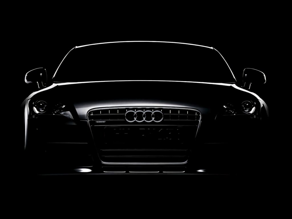 Audi R8 front view emerging from darkness showcasing sleek lines and iconic grille wallpaper