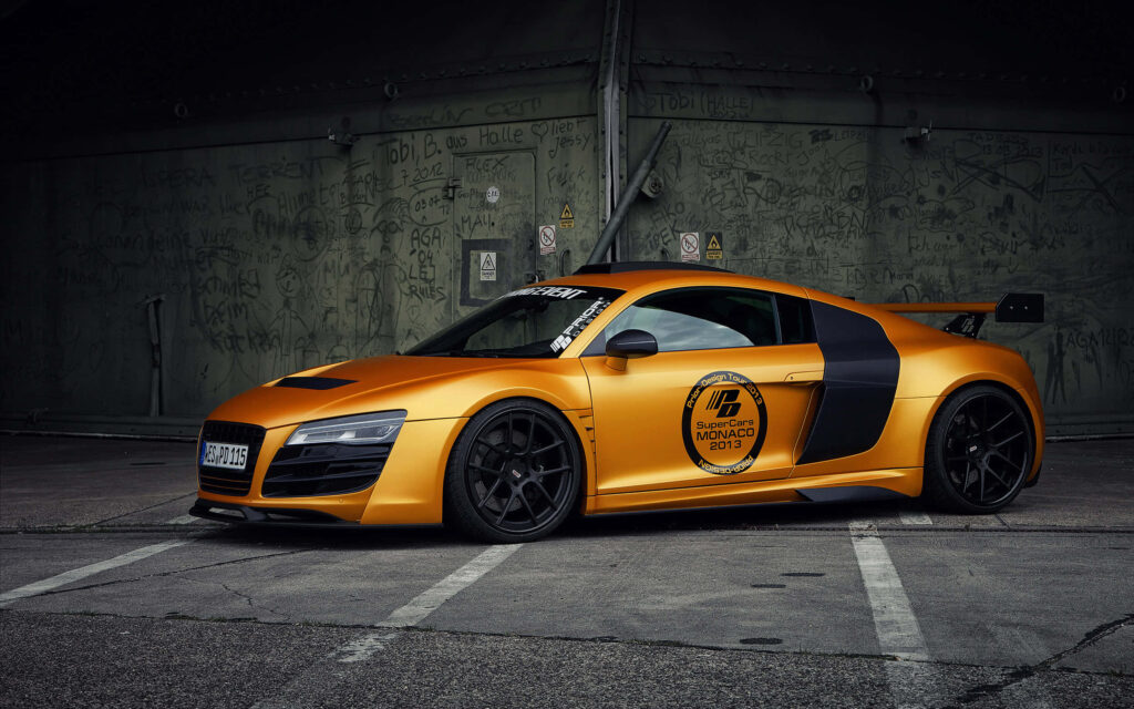 Audi R8 with Prior Design matte gold kit black wheels racing decals urban industrial backdrop Wallpaper