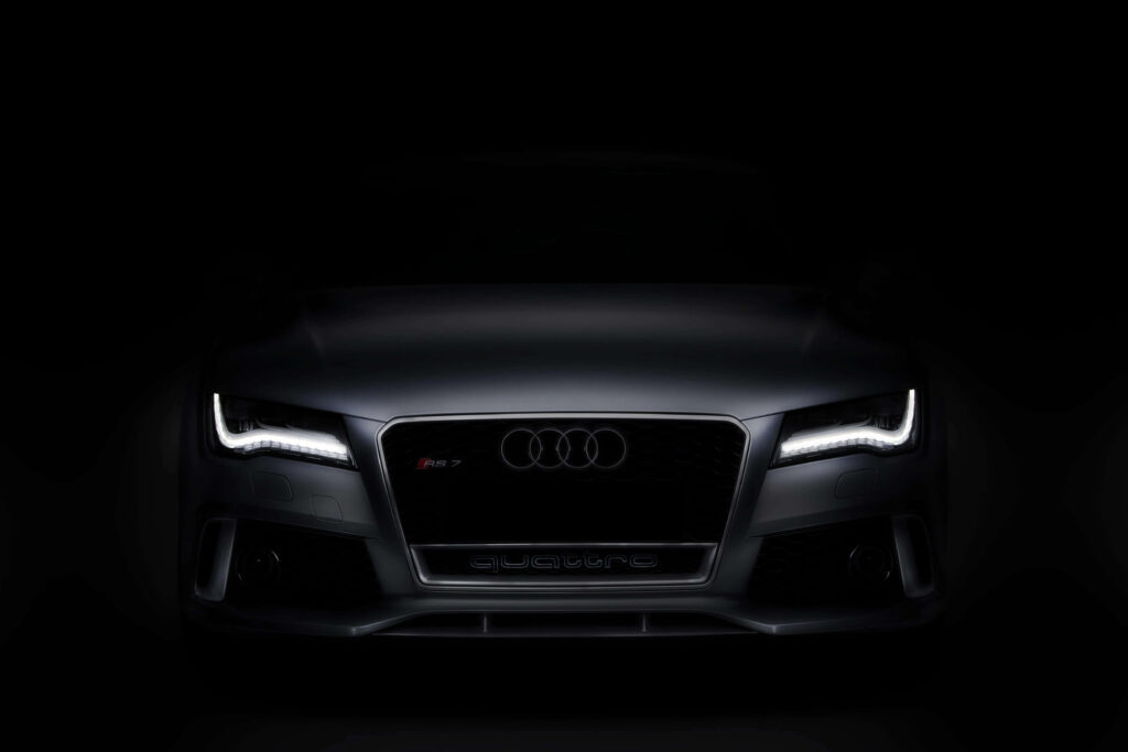 Audi RS7 Sportback front view with bold grille and LED headlights on dark wallpaper background