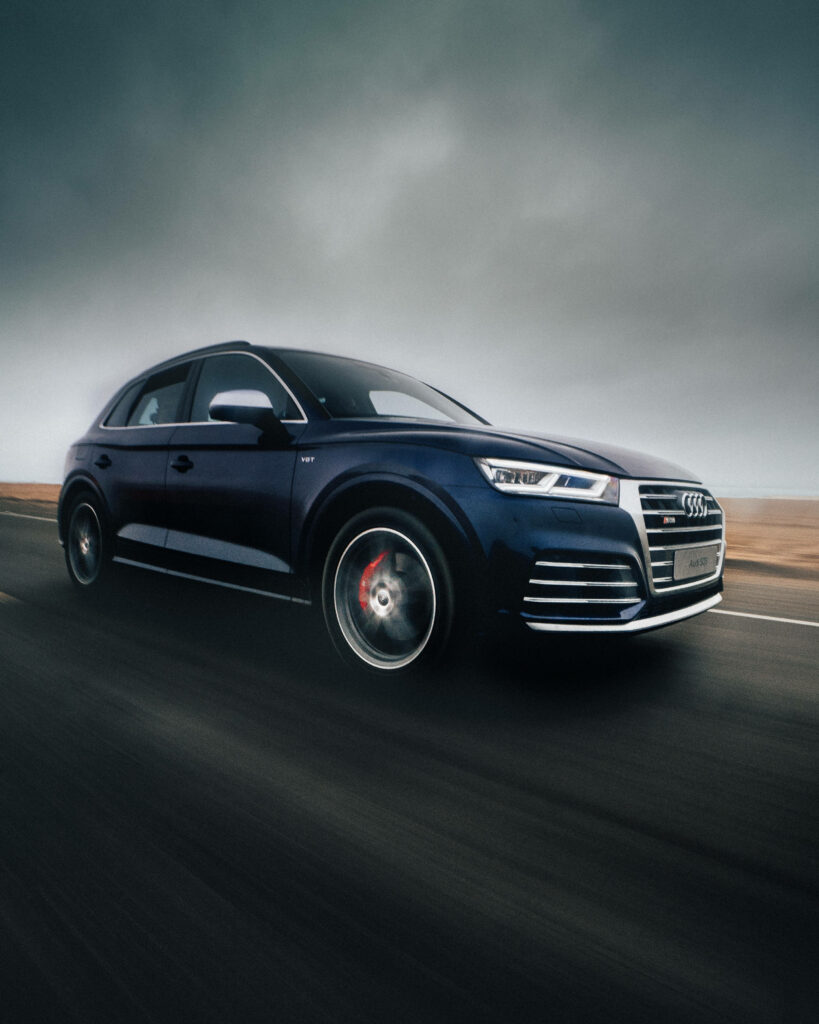 Audi SQ5 speeding on open road dynamic motion sleek design dramatic sky perfect wallpaper