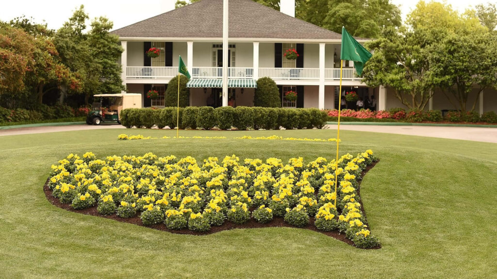 Augusta National Golf Course entrance with yellow US flower arrangement and scenic clubhouse Wallpaper