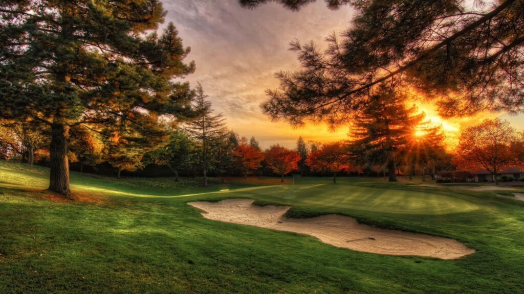 Augusta National Golf Course sunset with lush fairways sand bunker and colorful autumn trees Wallpaper
