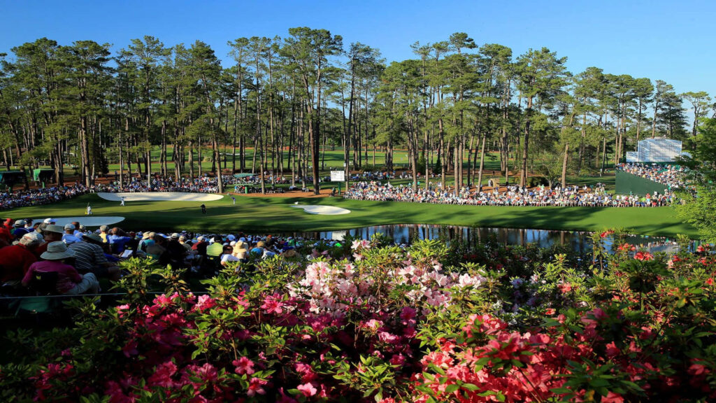 Augusta National Golf Course with lush fairways vibrant azaleas tall pines and clear blue sky Wallpaper
