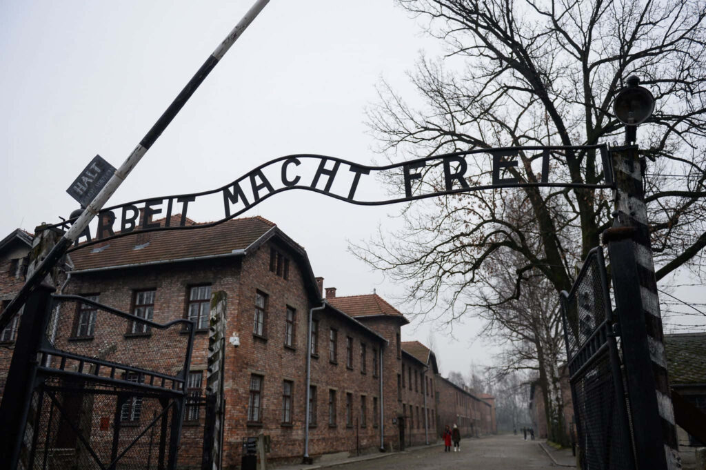 Somber Wallpaper of Auschwitz Gate: 'Arbeit Macht Frei' Background