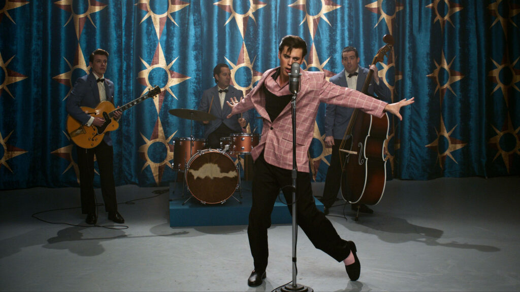 Austin Butler as Elvis Presley vibrant live performance retro 1950s fashion blue sunburst wallpaper