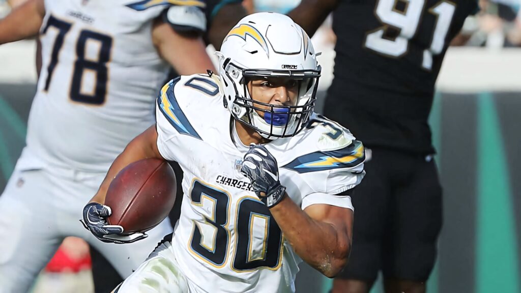 Austin Ekeler running with the ball in Los Angeles Chargers uniform during intense NFL game action Wallpaper