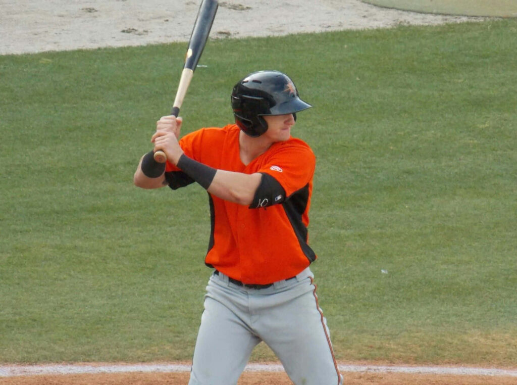 Austin Hays poised at bat on baseball field focused ready to swing dynamic sports wallpaper background