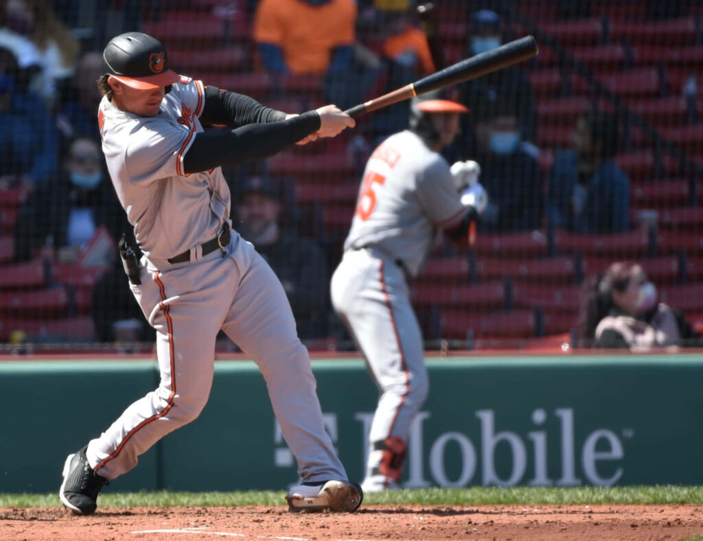 Austin Hays powerful mid-swing baseball batting form captured during game on field wallpaper background