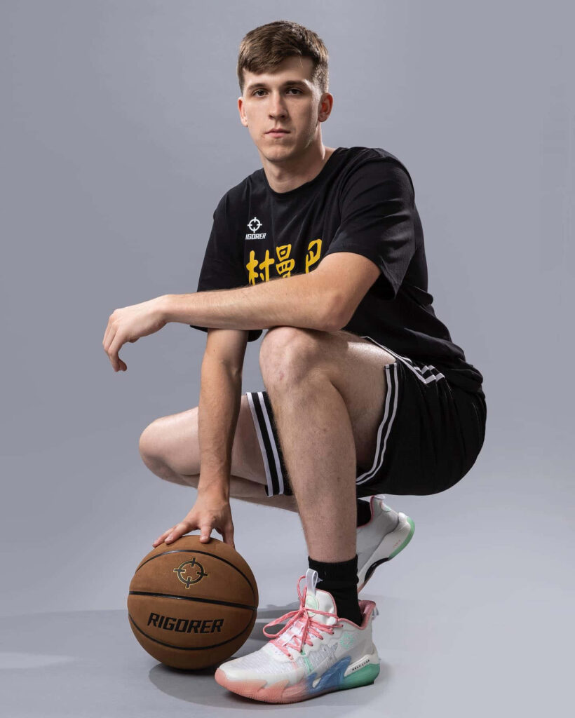 Austin Reaves basketball player portrait in athletic wear holding ball on simple gray background wallpaper