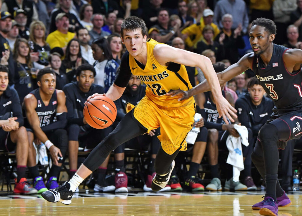 Austin Reaves dribbles past defender displaying agility and focus in intense basketball game wallpaper