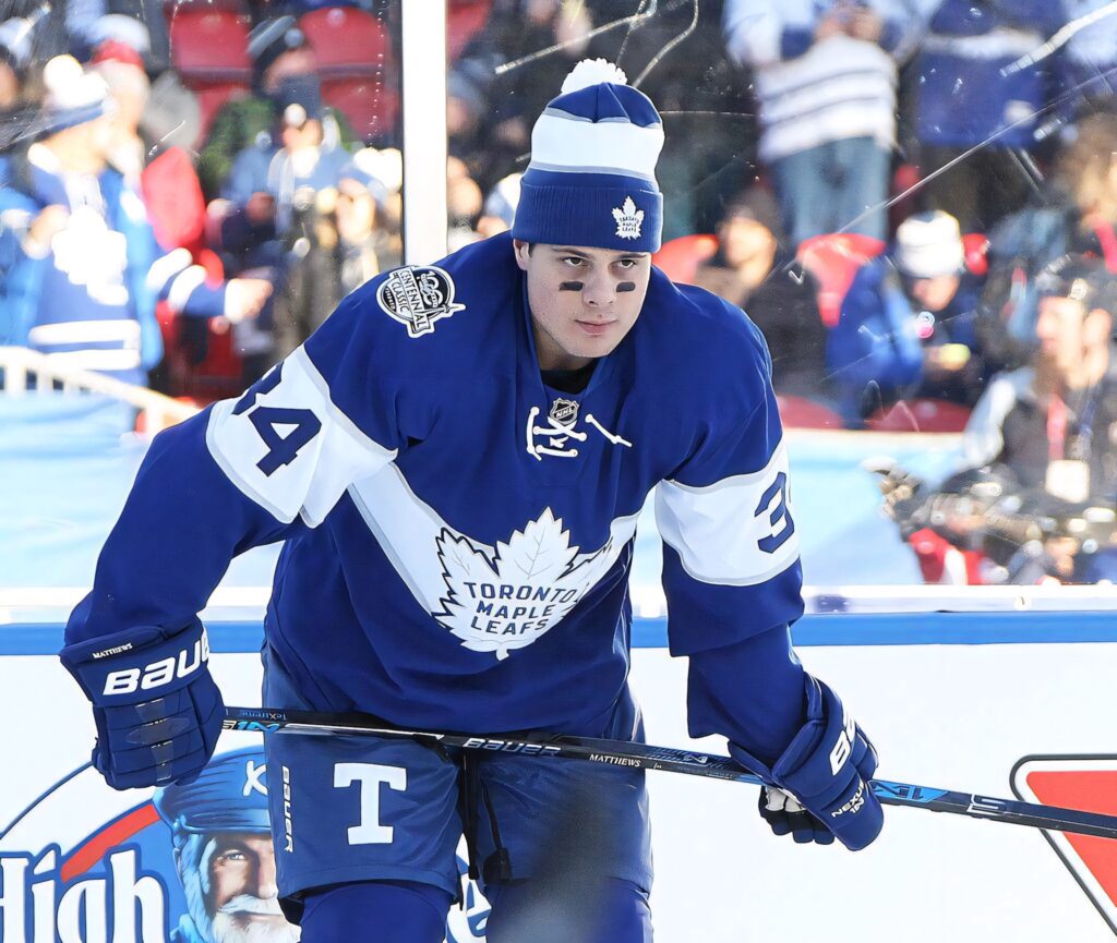 Auston Matthews in Toronto Maple Leafs uniform focused on ice during intense game play wallpaper