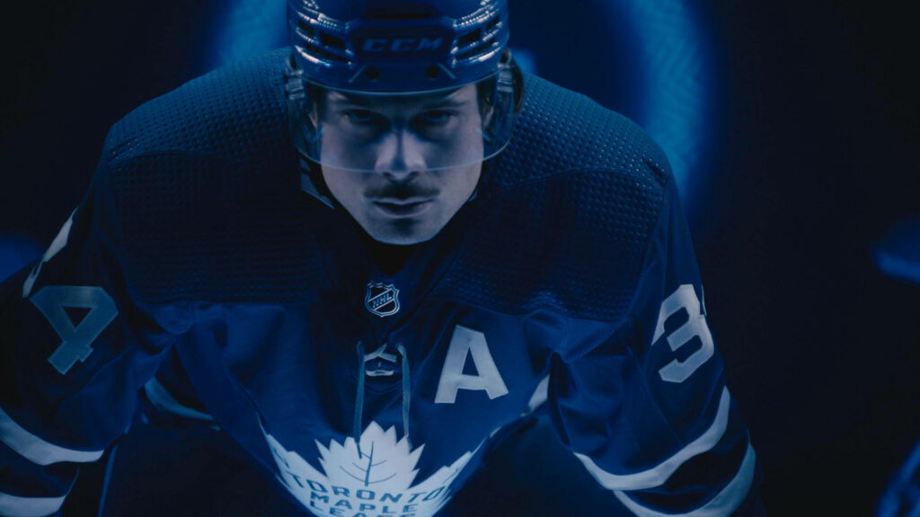 Auston Matthews in Toronto Maple Leafs jersey with intense lighting blue and black wallpaper