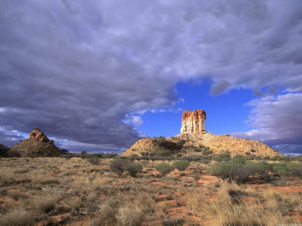 Australian canyon landscape with rugged peak golden grasslands and dramatic textured sky background Wallpaper