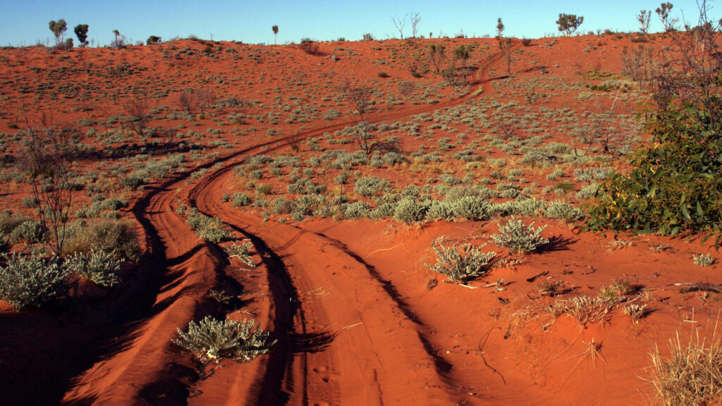 Australian Outback Canning Stock Route red sand tracks sparse desert vegetation blue sky wallpaper