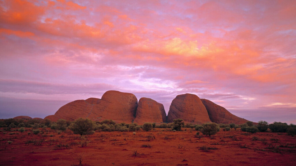 Australian Outback sunset with vivid pink sky unique rock formations red earth wallpaper background