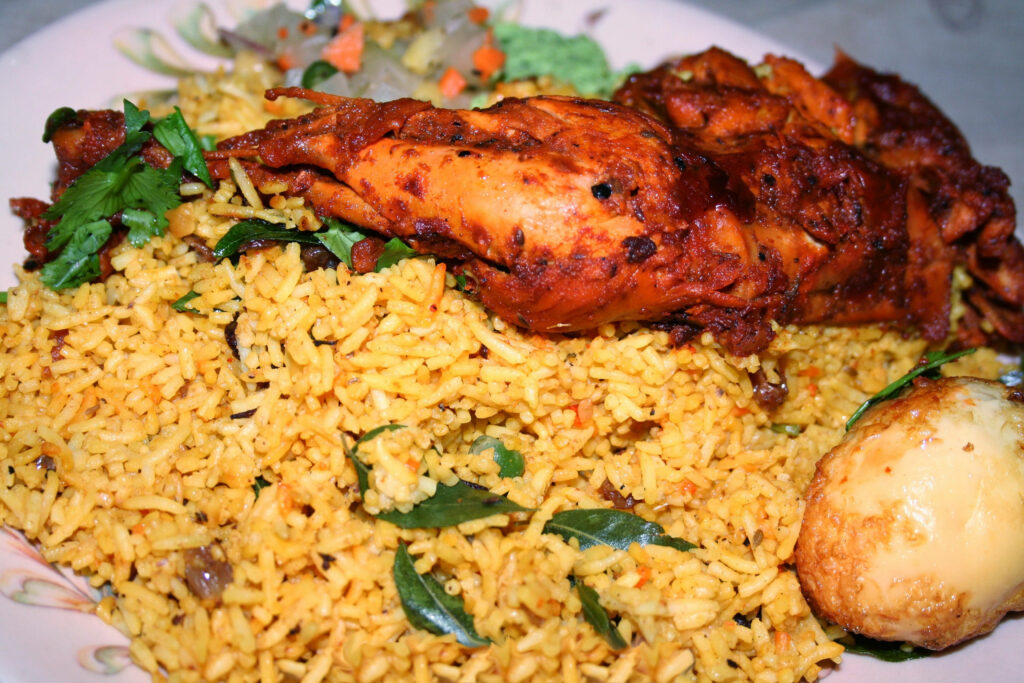 Chicken Biryani with spiced rice tender chicken boiled egg and fresh herbs traditional Indian dish Wallpaper