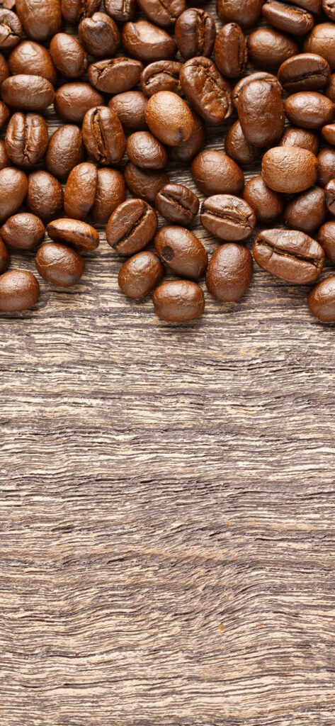 Freshly roasted coffee beans on rustic wood background capturing authentic coffee aroma Wallpaper