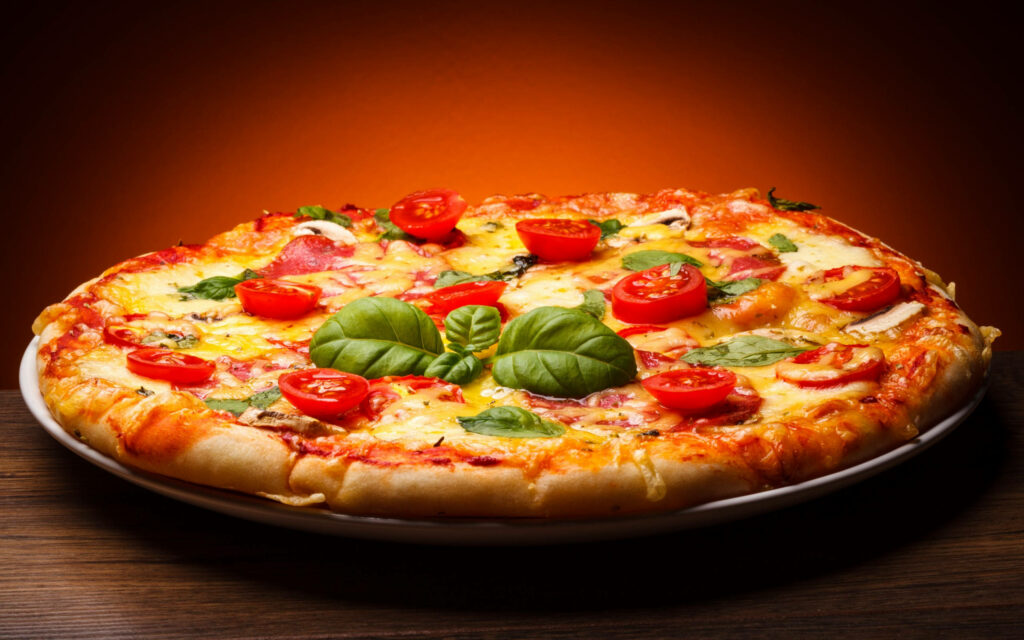 Neapolitan pizza with melted cheese fresh basil and cherry tomatoes on a warm background Wallpaper