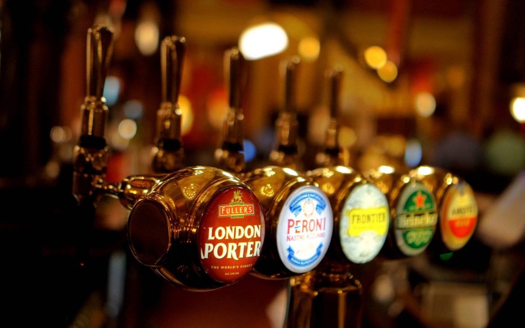 Close-up of polished beer taps with Fullers London Porter Peroni Frontier and Heineken branding Wallpaper