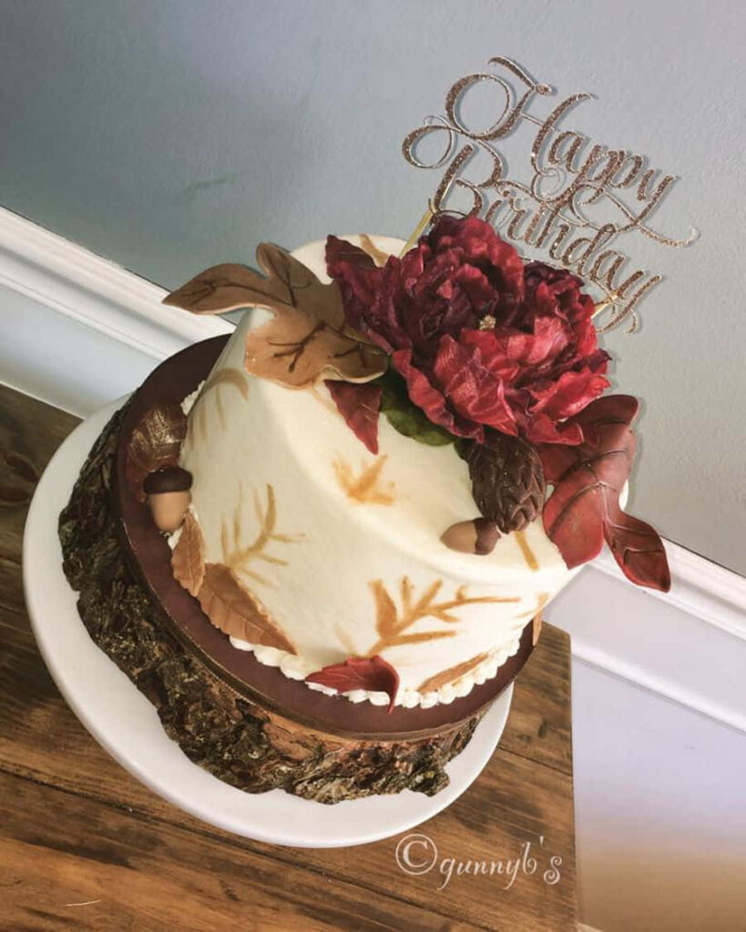 Rustic Autumn Birthday Cake with Floral Decor on Wooden Base Wallpaper