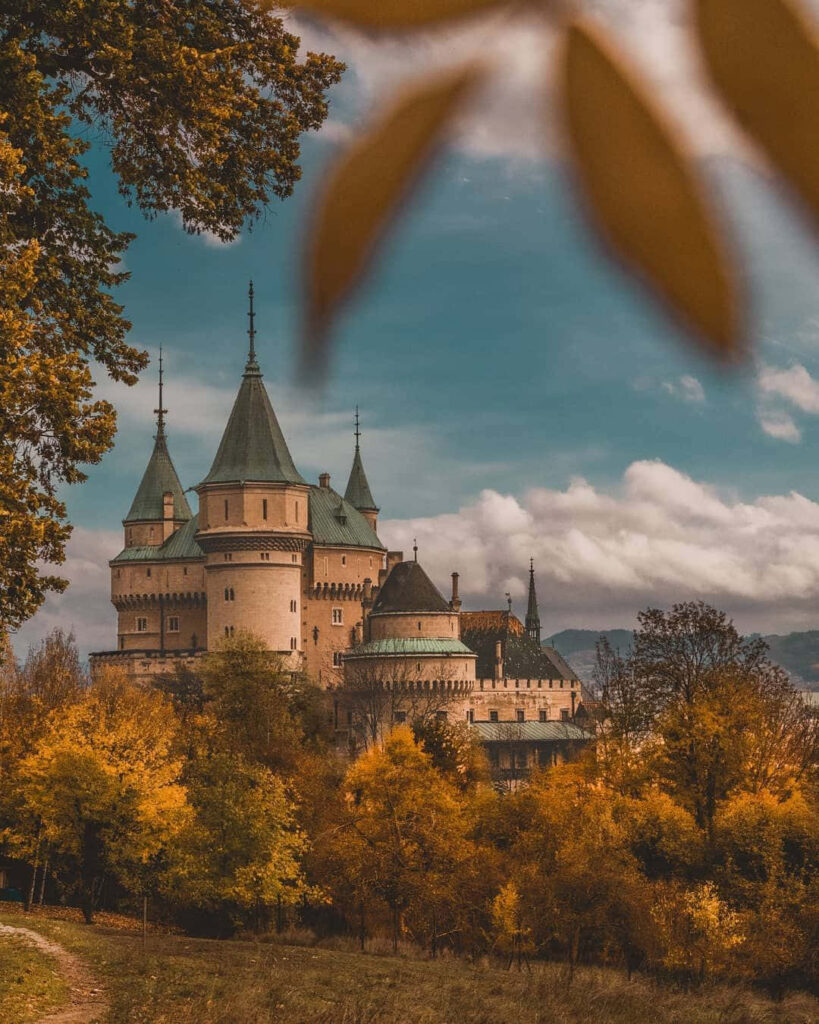 Autumn Bojnice Castle Slovakia wallpaper vibrant fall foliage medieval architecture clouds