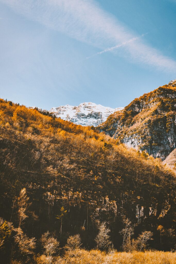 Scenic autumn mountain landscape with snow-capped peaks golden slopes and clear blue sky wallpaper