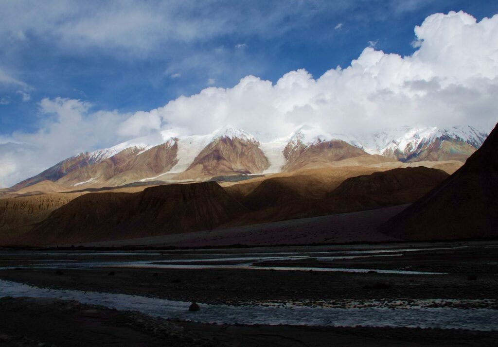 Snow-capped mountains autumn hills and reflective river under dramatic sky natural landscape wallpaper
