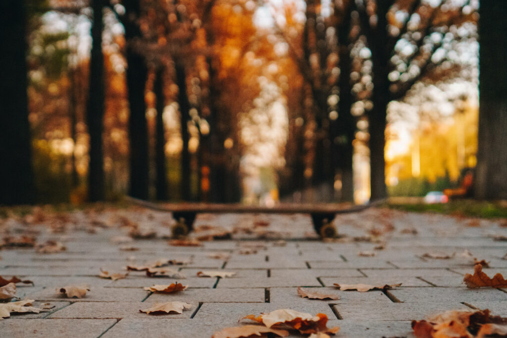 Riding Solo: Glimpses of Skateboarding Serenity on Autumns' Pathway in Kazakhstan Wallpaper