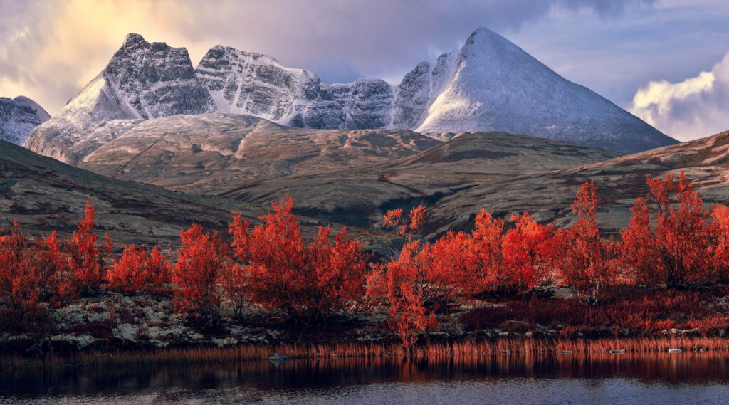 Rondane National Park autumn landscape with red foliage snow-capped peaks reflected in lake in 4K Wallpaper