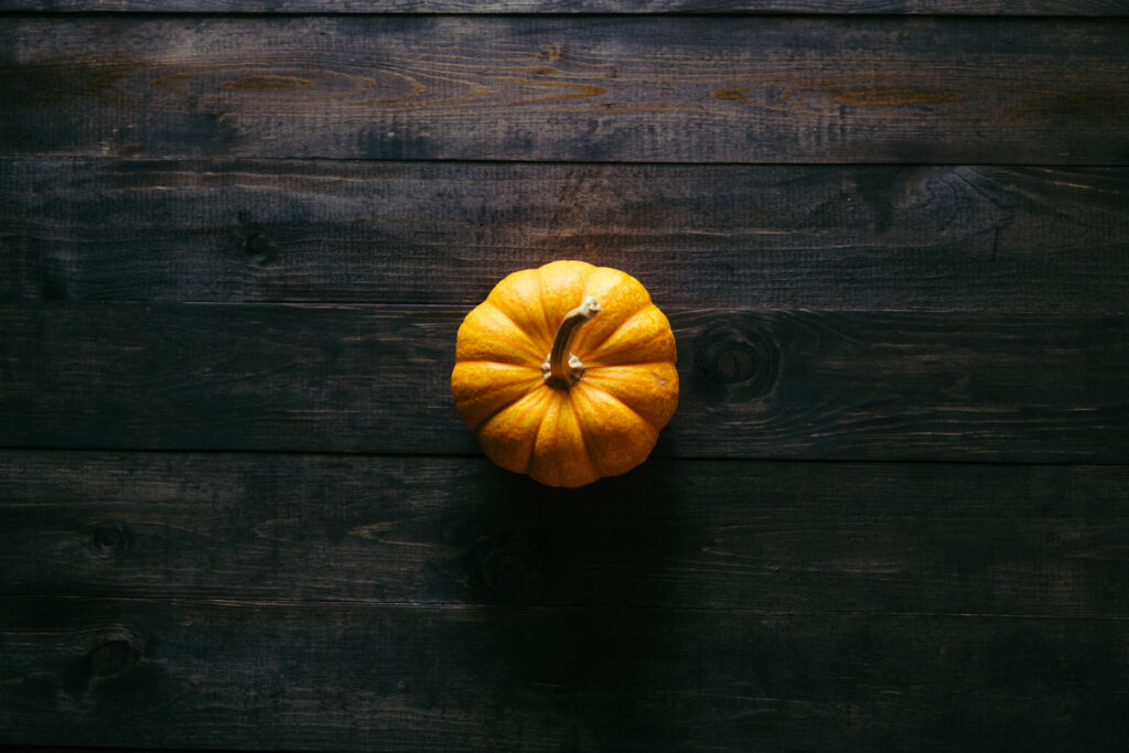 Golden Autumn: Vibrant Pumpkin on Rustic Wooden Board Wallpaper