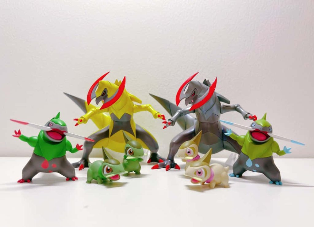 Axew Fraxure Haxorus collectible Pokémon figures shiny and standard on white background wallpaper