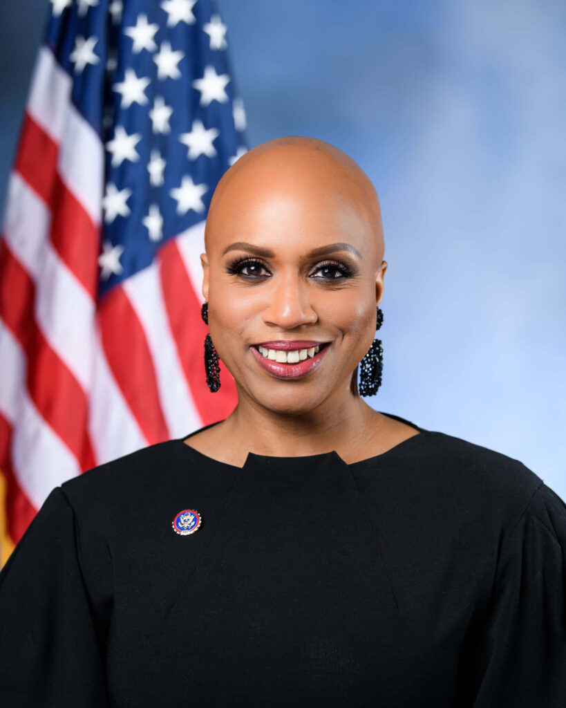 Ayanna Pressley official portrait standing confidently before US flag symbolizing leadership Wallpaper