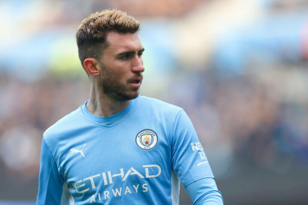 Aymeric Laporte focused in Manchester City jersey looking sideways on the football field wallpaper