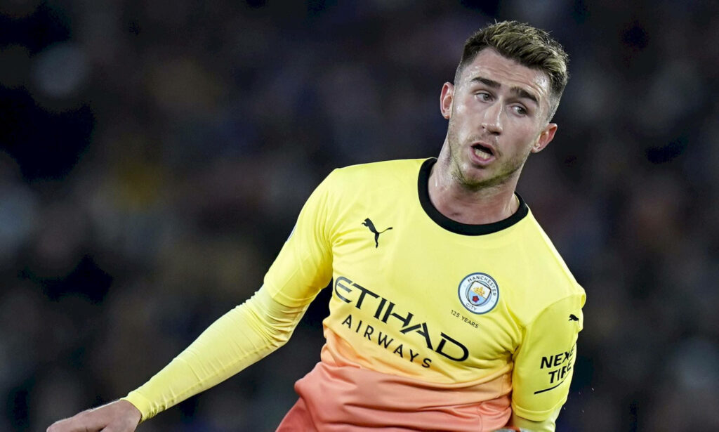 Aymeric Laporte in yellow gradient Manchester City jersey displaying focus and intensity wallpaper