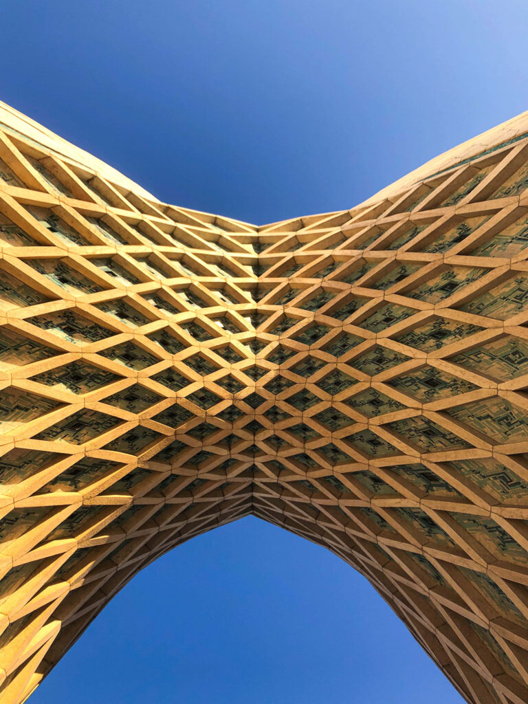 Azadi Tower underside geometric patterns in Tehran Iran clear blue sky wallpaper background