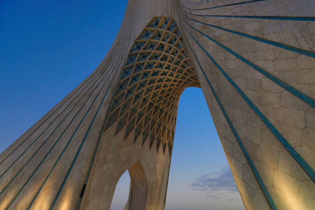 Azadi Tower illuminated at sunset showcasing Tehran architecture against clear evening sky Wallpaper