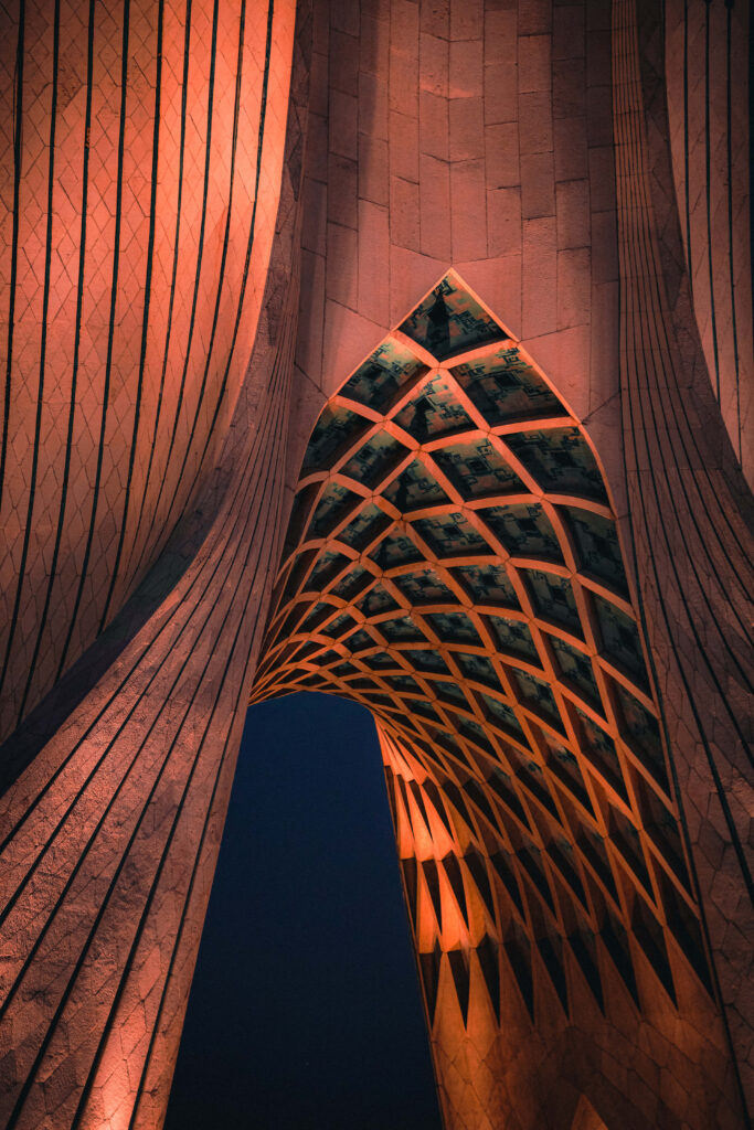 Azadi Tower Tehran illuminated red at night showcasing geometric architectural patterns wallpaper