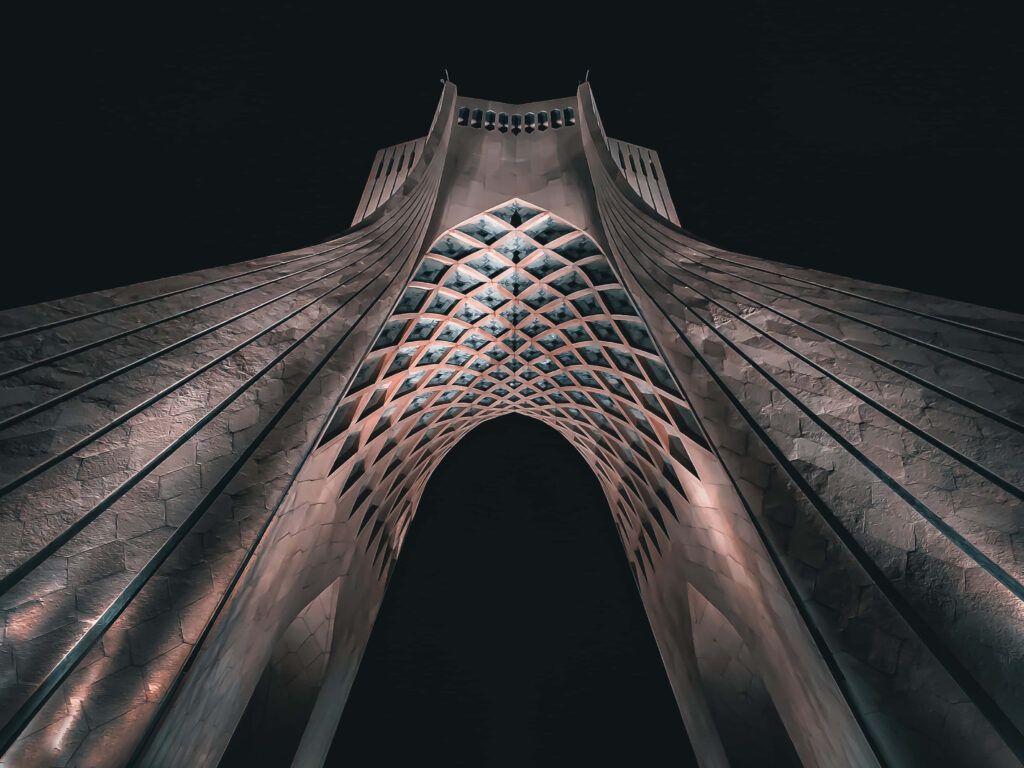 Azadi Tower Tehran illuminated at night showcasing intricate architecture dramatic wallpaper background