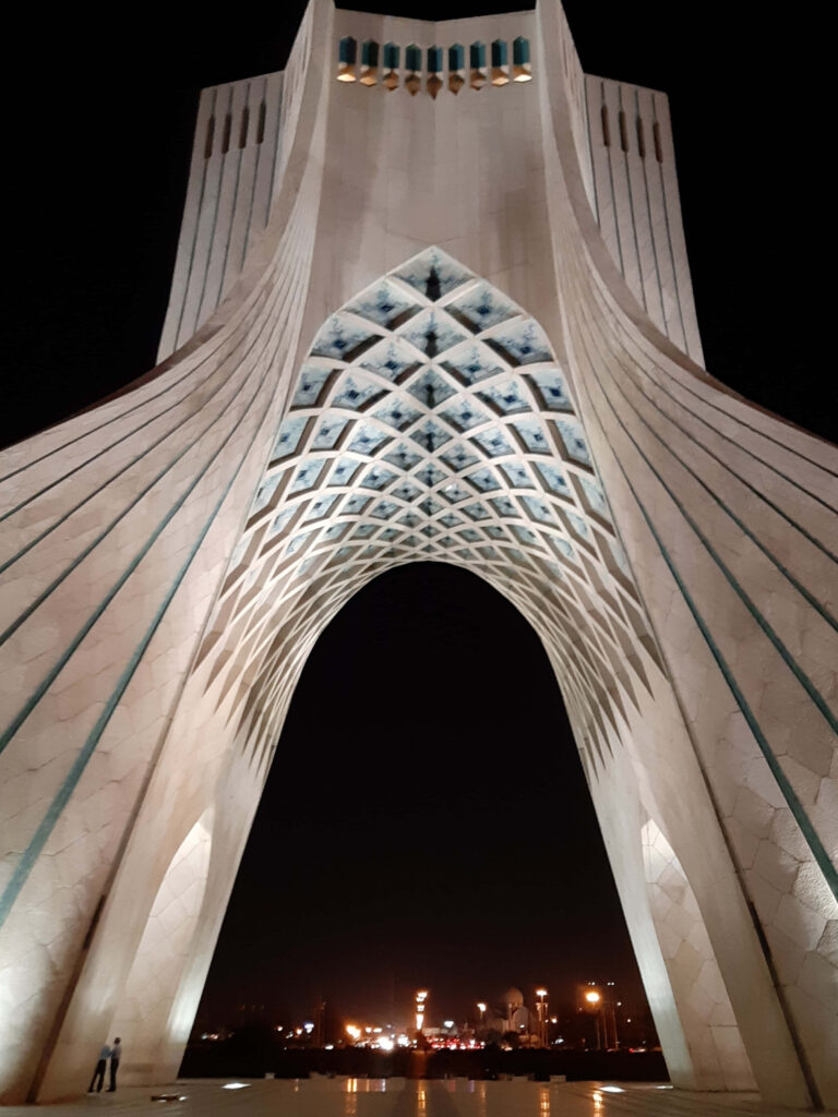 Azadi Tower at night in Tehran illuminated concrete architecture with city lights background Wallpaper