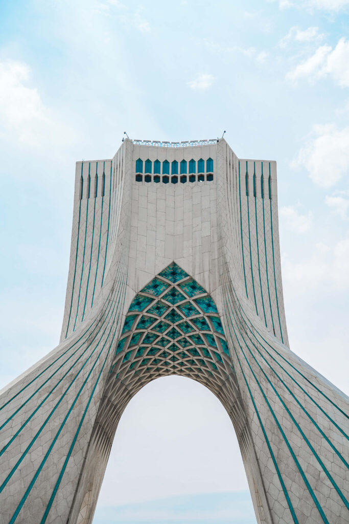 Azadi Tower in Tehran under cloudy sky showcasing elegant architecture and cultural landmark Wallpaper