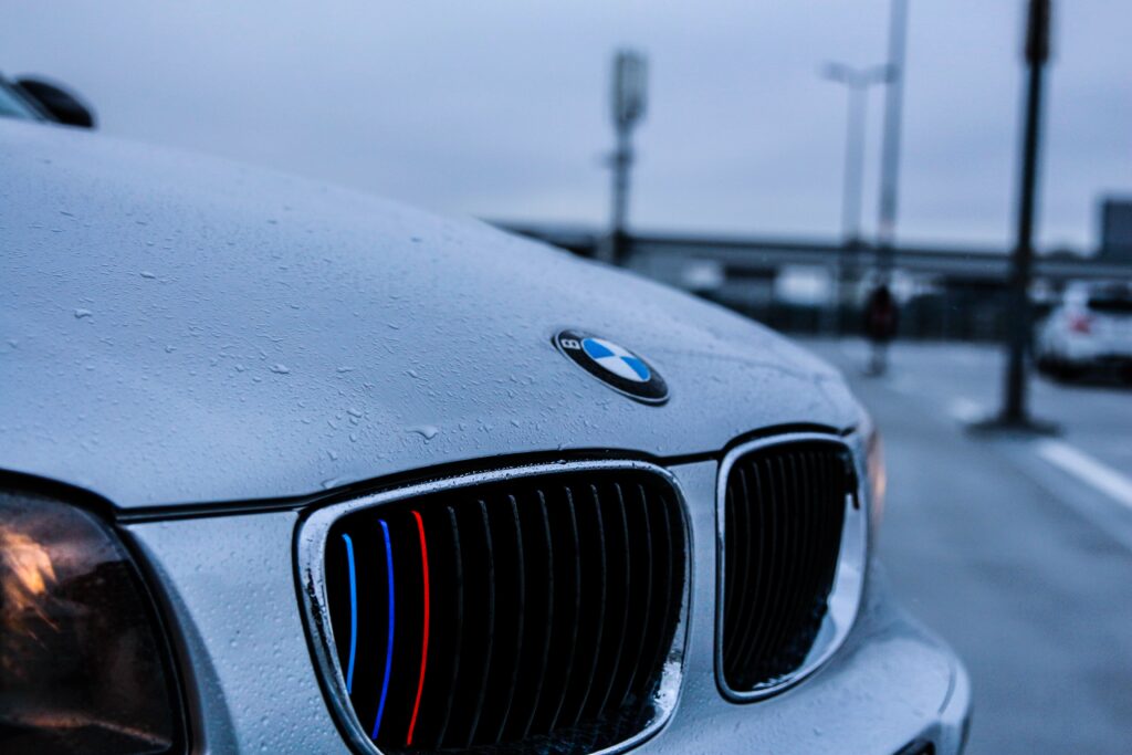 Close-Up BMW Car Hood Wallpaper: Iconic Logo & Raindrop Texture