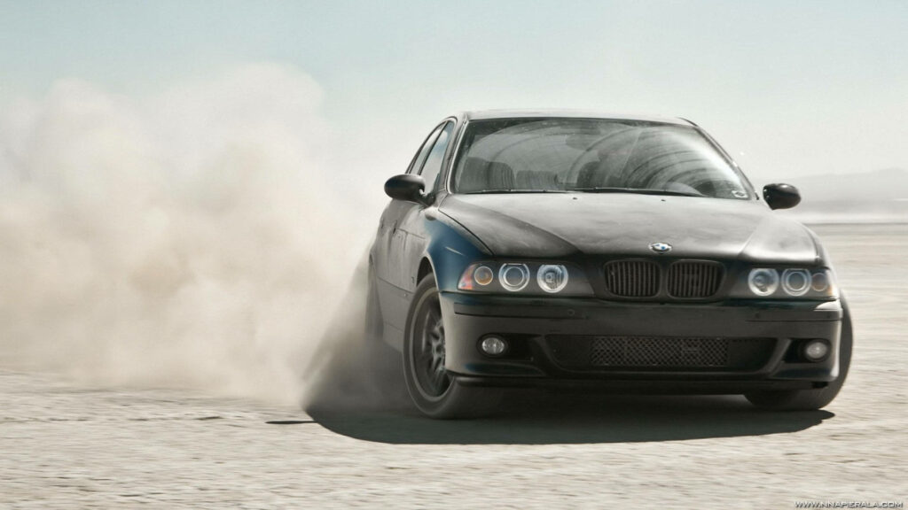 Powerful BMW drifting on sunlit dusty landscape dynamic car wallpaper background