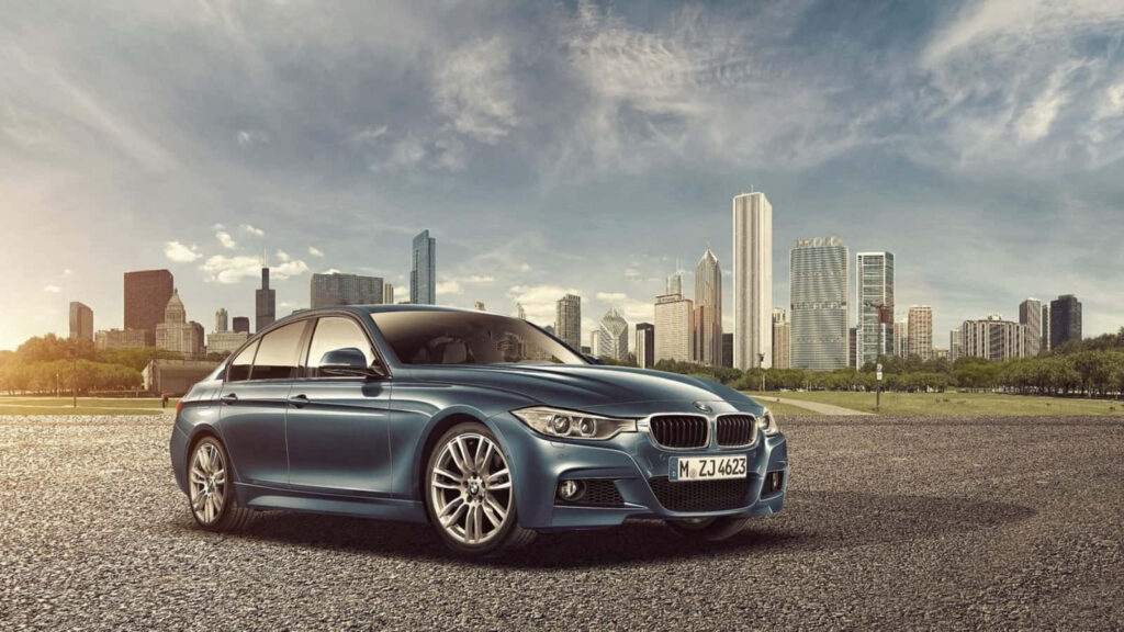 BMW F3 luxury car parked by modern city skyline under dramatic partly cloudy sky wallpaper background
