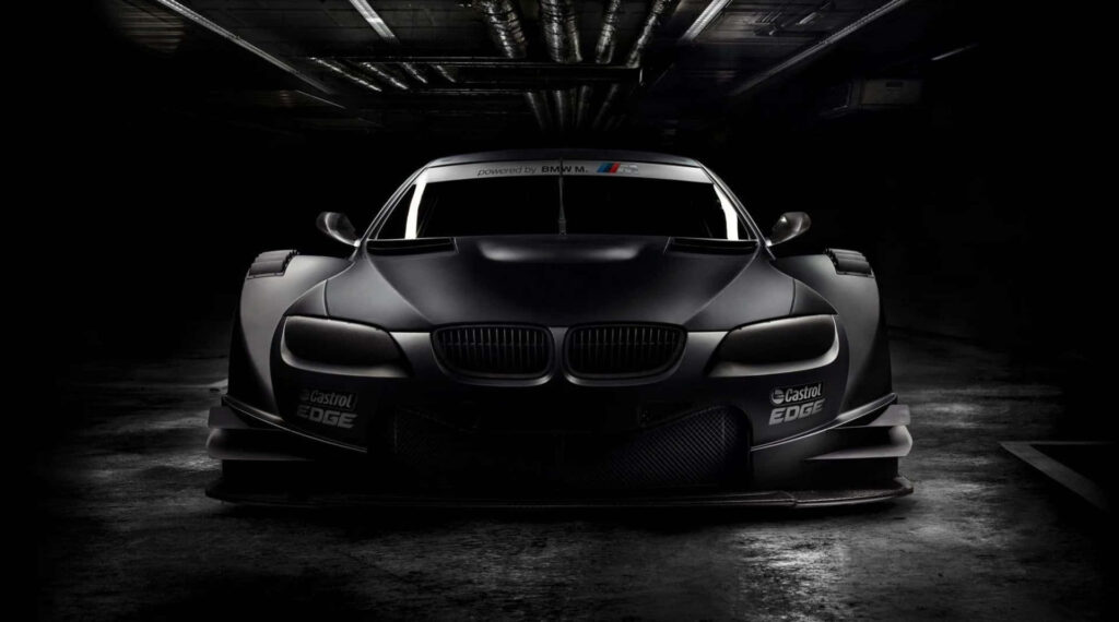 BMW M3 GT3 front view in dim garage showcasing aggressive aerodynamic racing design wallpaper