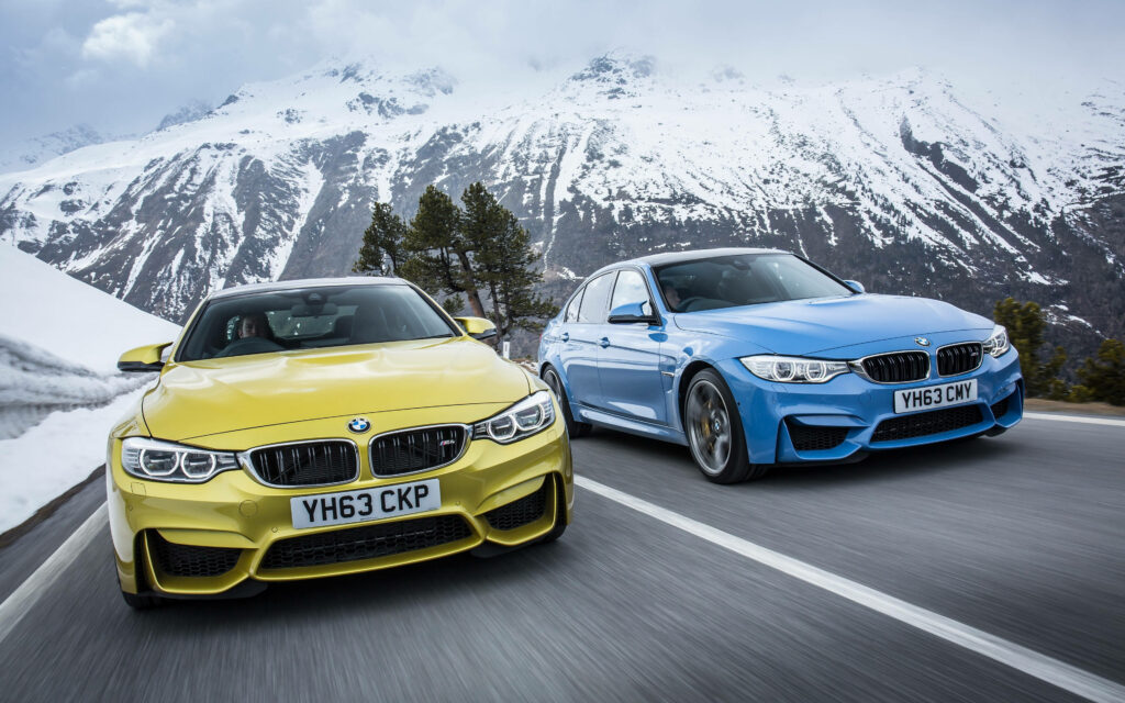 Breathtaking Alpine Majesty: Twin BMW M4s Embrace the Snow-Cloaked Peaks while Ruling the Road Wallpaper