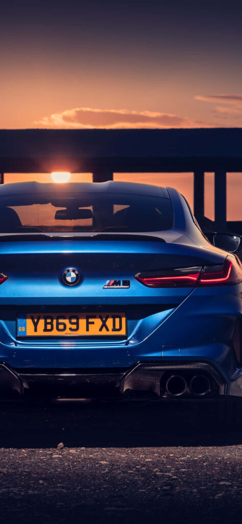 BMW M8 metallic blue parked at sunset sleek design dynamic lines automotive wallpaper background