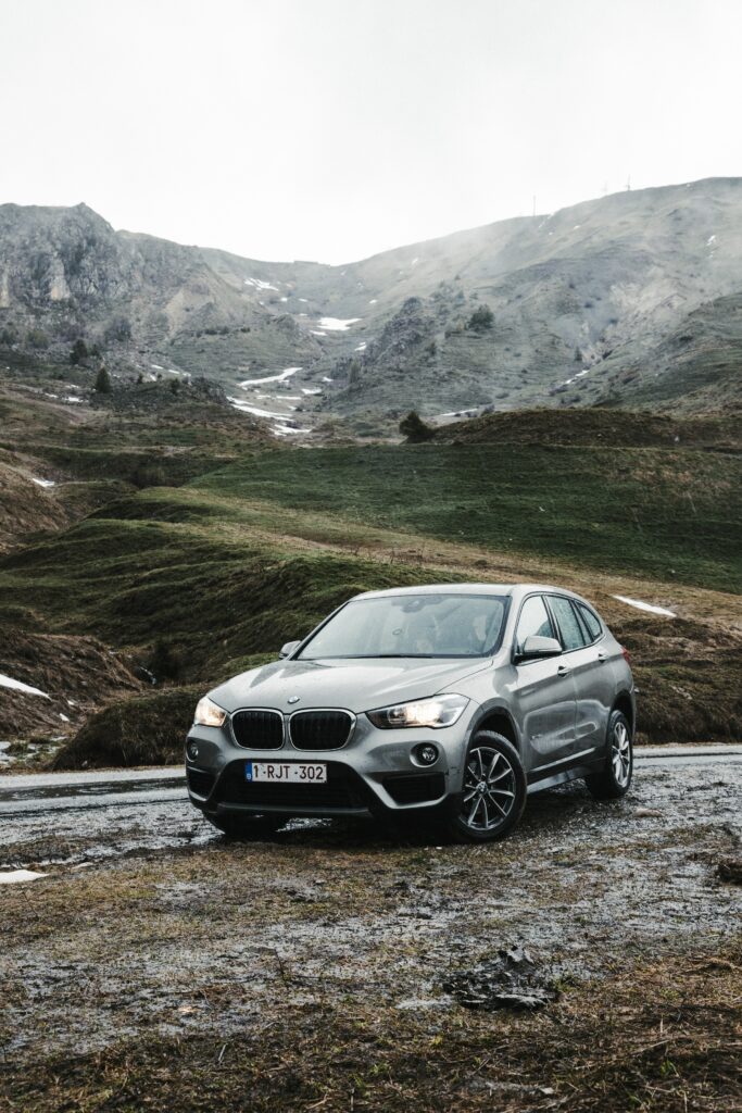 Sleek BMW SUV on Rocky Path: Adventure-Ready Mountain Backdrop Wallpaper