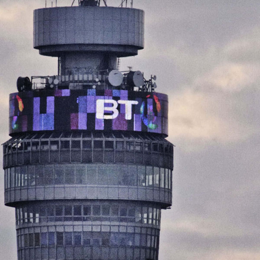 Close-up of BT Tower London with round digital screen and BT logo under cloudy sky background Wallpaper