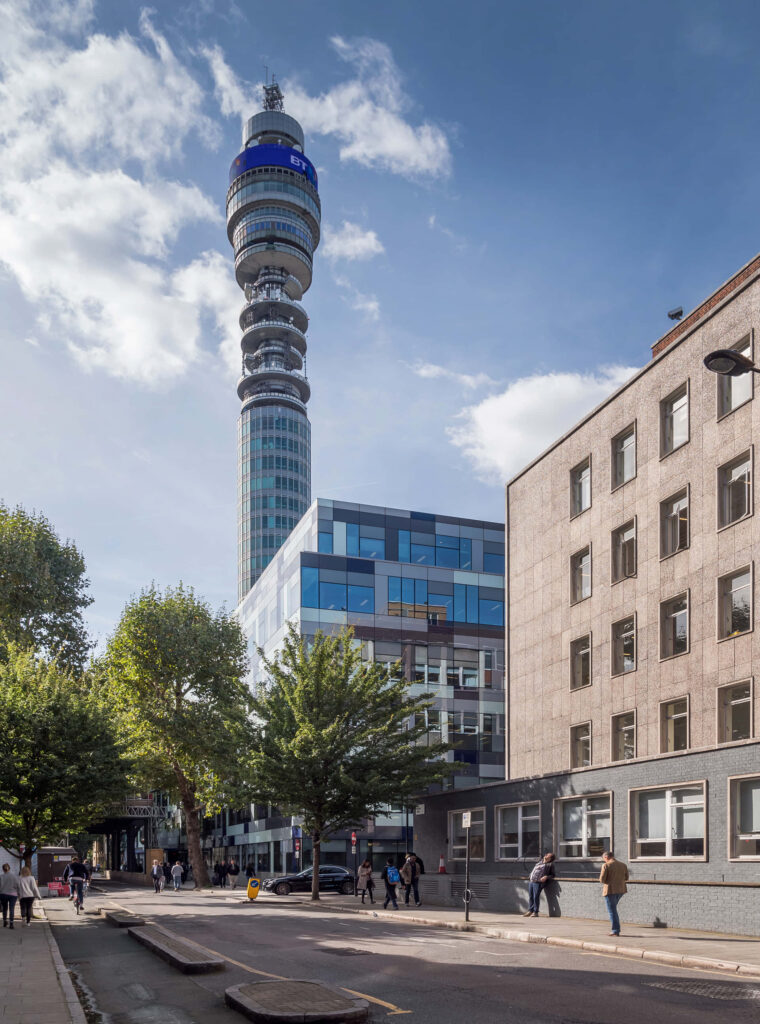 BT Tower rising above London cityscape with modern and classic buildings under blue sky Wallpaper