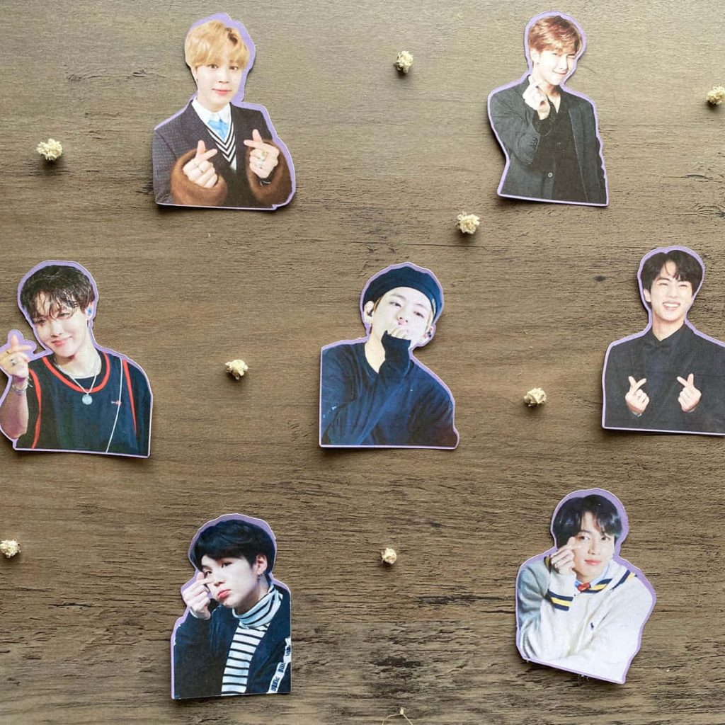 BTS finger heart stickers on rustic wood with dried flowers K-pop wallpaper background